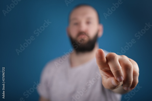 blue background young man finger pointing touch © vegefox.com