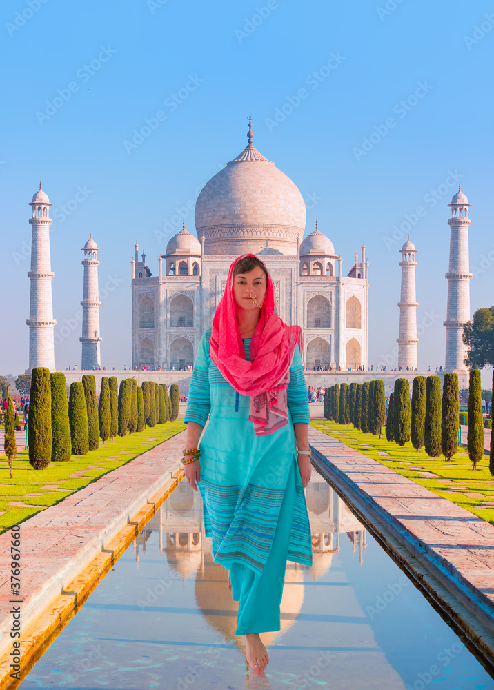 Φωτογραφία Taj Mahal, Agra / Young woman in traditional indian clothes walking on the water