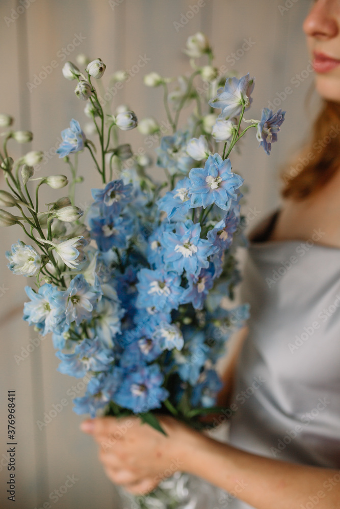 woman holding bouquet of flowers delphinium