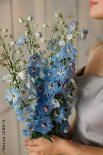 woman holding bouquet of flowers delphinium