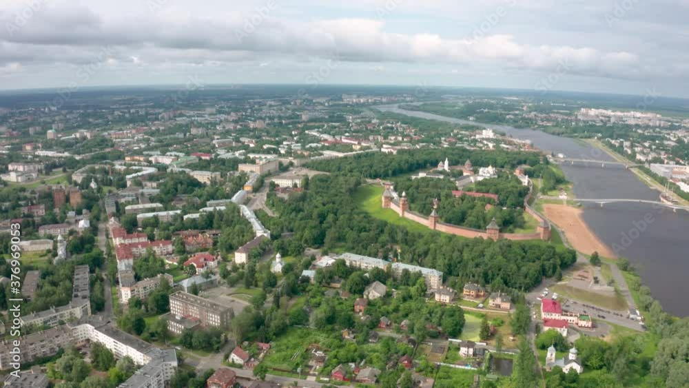 Panoramic aerial view of the Volkhov River and the old town of Veliky Novgorod, the red brick Kremlin in the rays of the setting sun and natural attractions of Russia. Panoramic aerial view of the Volkhov River and the old town of Veliky Novgorod, the red brick Kremlin in the rays of the setting sun and natural attractions of Russia.