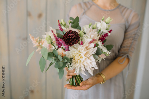 Cheerful young lady with long wavy hair being excited to get bouquet