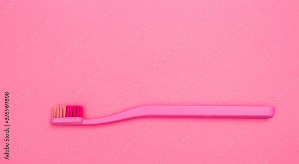 Pink toothbrush isolated on pink background. Pink toothbrush close up top view Pink toothbrush isolated on pink background. Pink toothbrush close up top view