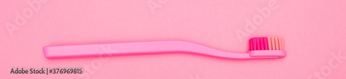 Pink toothbrush isolated on pink background. Pink toothbrush close up top view