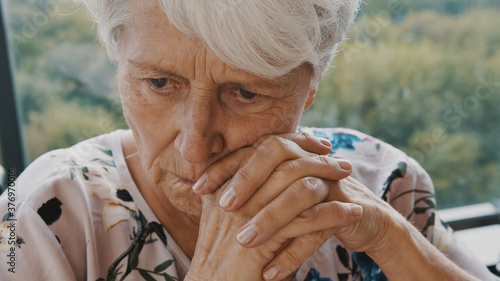 Elderly caucasian woman in nursing care home, with sadness in her eyes, self isolation due to the global COVID-19 Coronavirus pandemic. High quality photo photo