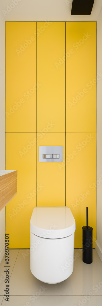 Toilet with yellow wall, vertical panorama Toilet with yellow wall, vertical panorama
