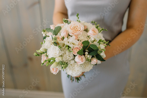 Cheerful young lady with long wavy hair being excited to get bouquet
