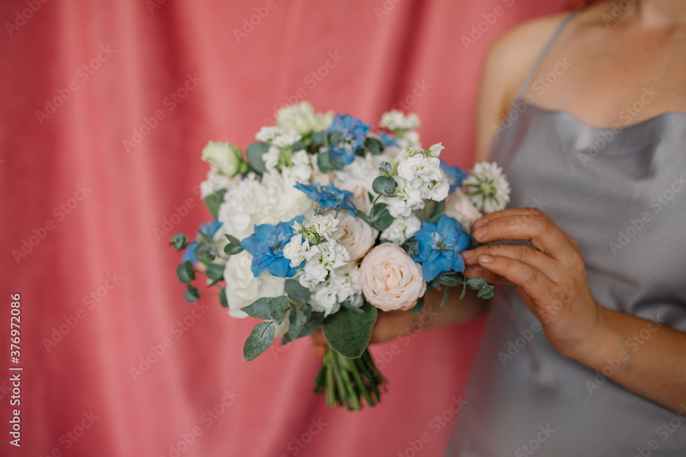 Very nice young woman holding big and beautiful colourful flower wedding bouquet
