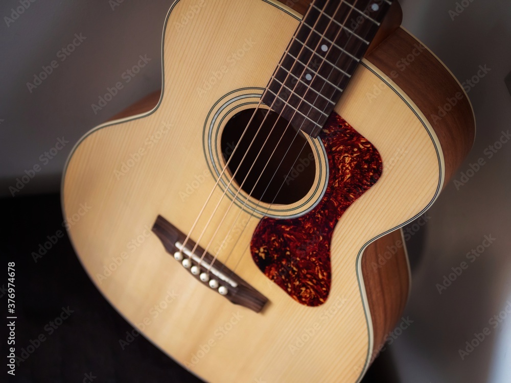 Obraz premium Acoustic guitar in the corner of a room