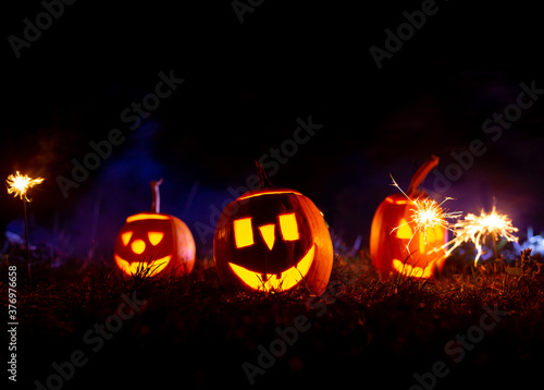 Halloween pumpkins over blue background with smoke with copy space. 
