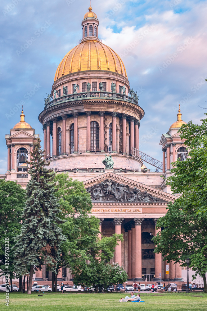 Saint Petersburg, Russia - June 16, 2020 - Magnificent St. Isaac's Cathedral with people resting on the lawn