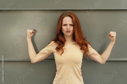 Macho young woman flexing her muscles photo