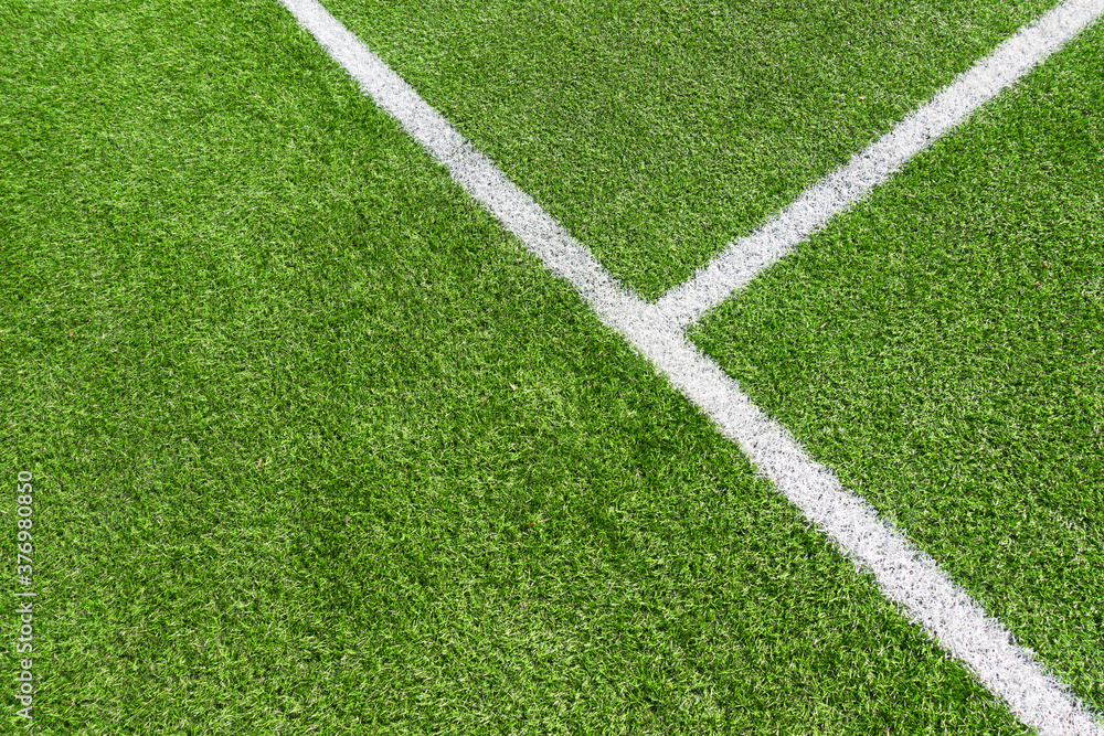 Green artificial grass turf soccer football field background with white line boundary. Top view