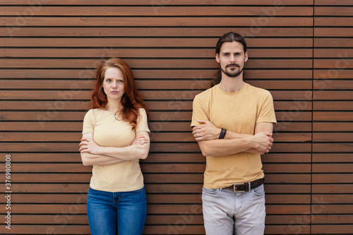 Serious young couple with folded arms