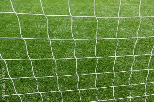 Close up of football soccer goal net with green grass background