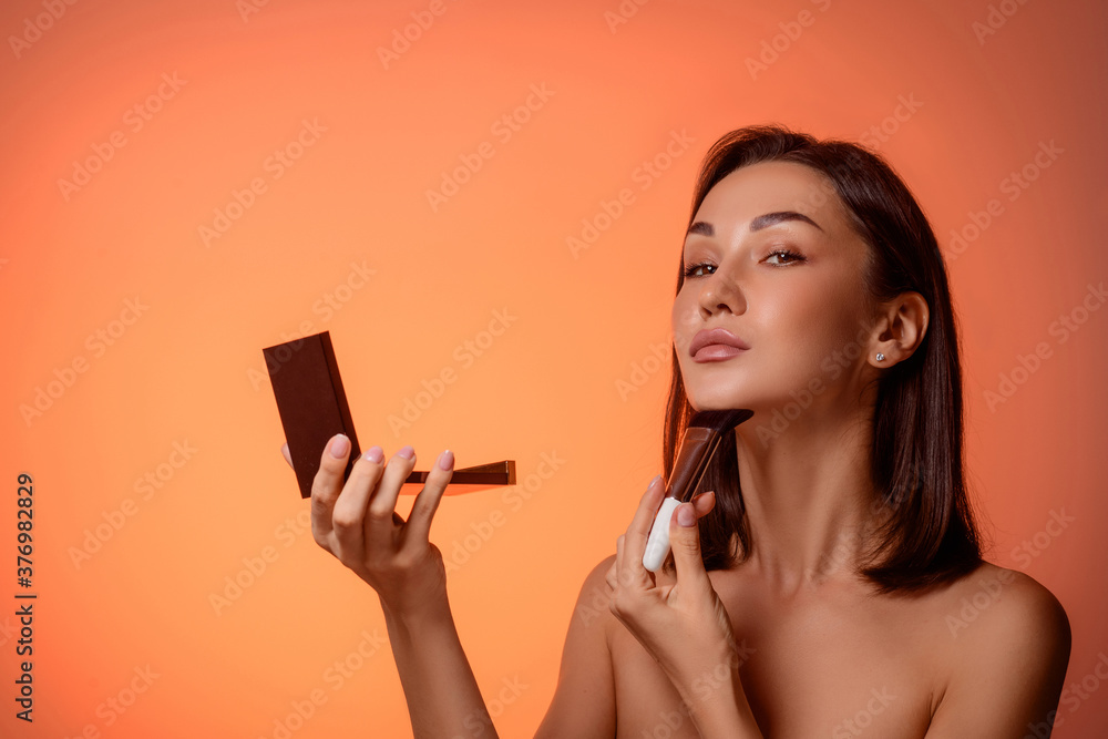 Beautiful woman with cosmetic powder brush for makeup and brush on her chin. Cute caucasian girl show her perfect skin Beautiful woman with cosmetic powder brush for makeup and brush on her chin. Cute caucasian girl show her perfect skin