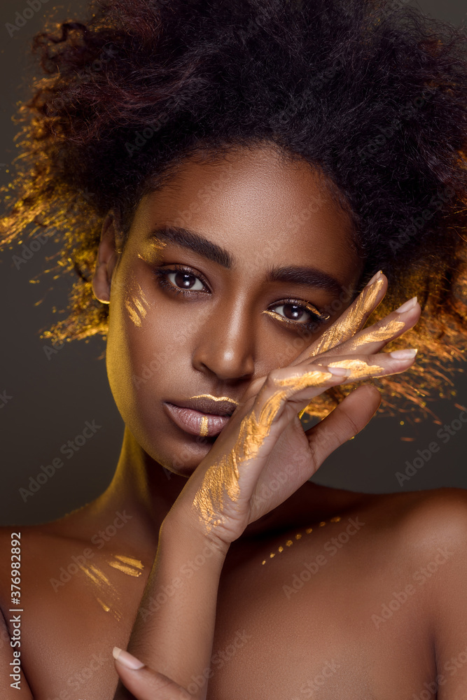 Beautiful african woman with natural make-up with gold sparkles on her face and body. Ethnic makeup. Fashion and Style - obrazy, fototapety, plakaty 