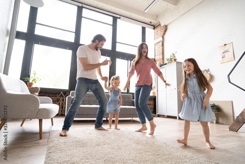 Naklejka premium happy family mother father and child daughter dancing at home