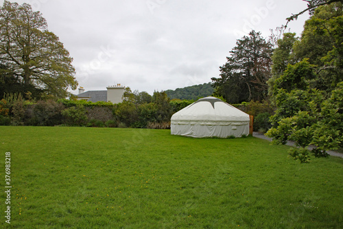 A traditional Mongolian yurt in the corner of a grassy field in England