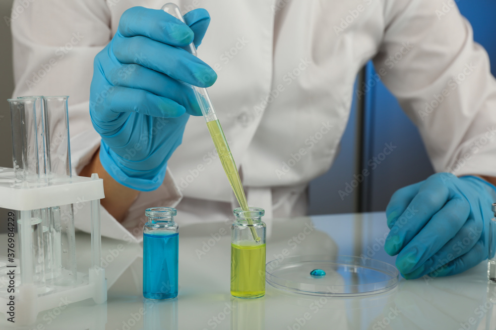 Fototapeta premium laboratory assistant's hands hold laboratory glassware during the research