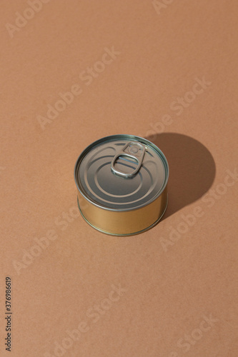 Single tin can with preserved food placed on brown surface