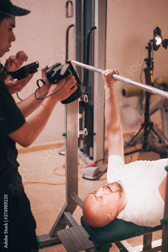 Professional shooting of bold man in gym