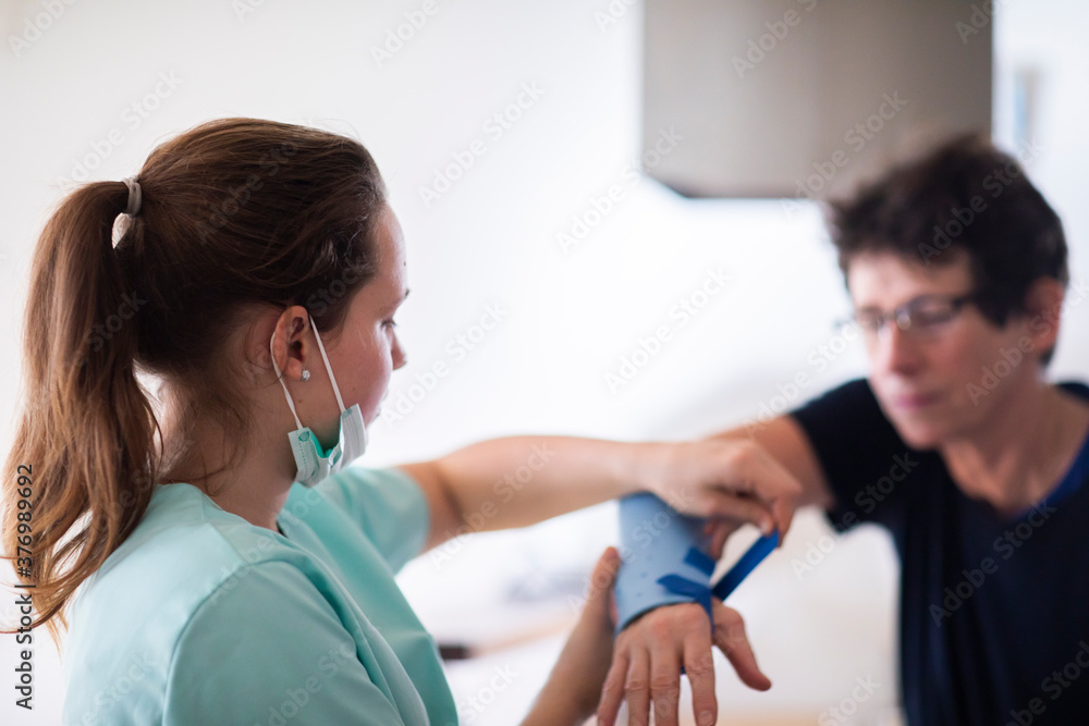 nurse making a armbracer to a patient female nurse making a armbracer to a patient female