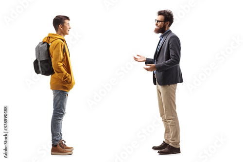 Full length profile shot of a male teenage student listening to a bearded man