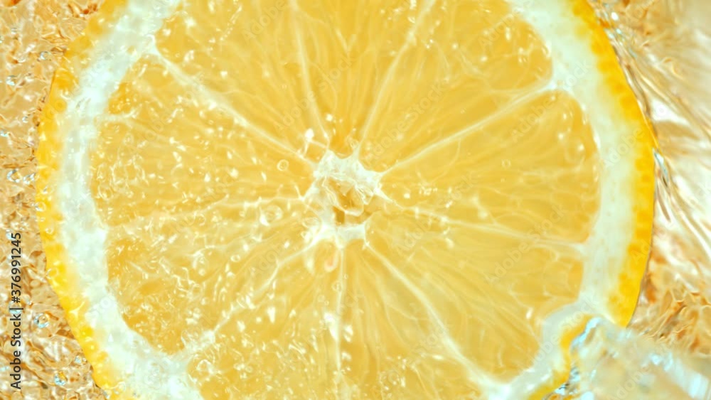 Super Slow Motion Shot of Splashing Water on Rotating Lemon Slice at 1000fps.
