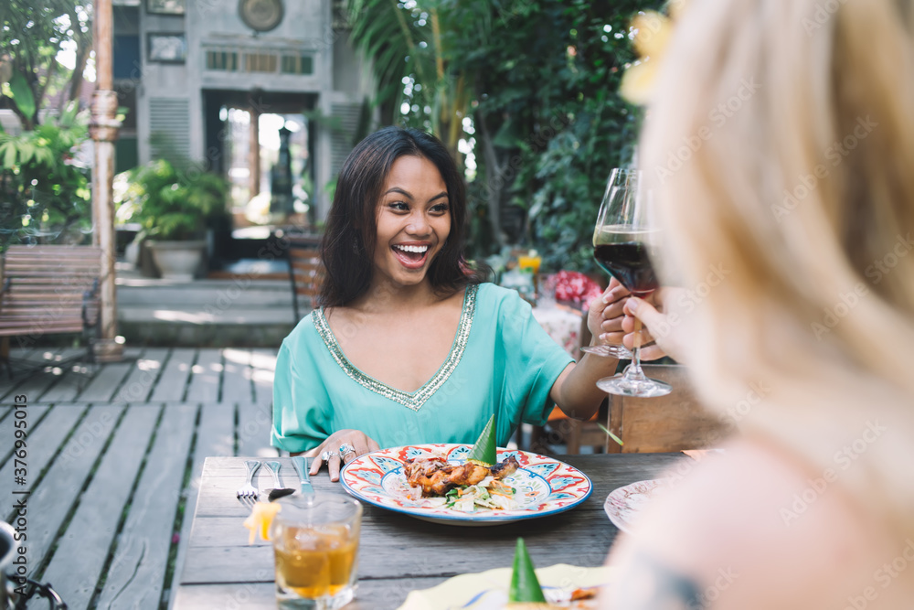 Happy women drinking wine in outdoor cafe