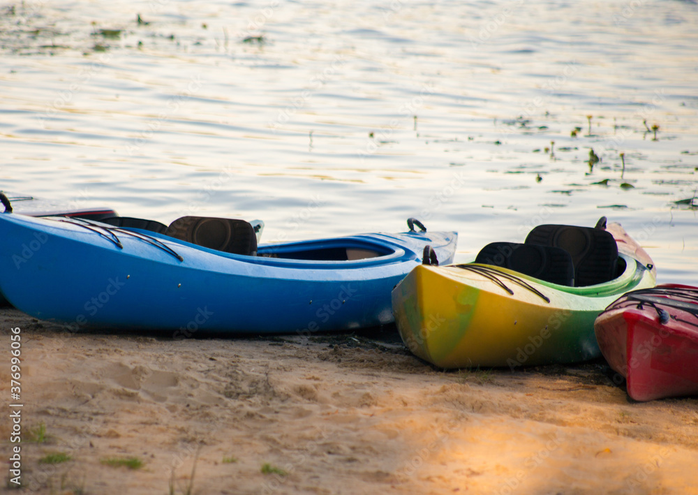 Professional sports kayak lies on the river bank Professional sports kayak lies on the river bank