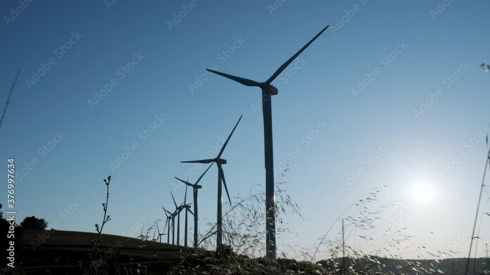 Video of some wind turbines generating clean energy at full capacity in the mountain.