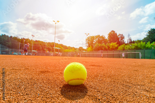 Yellow tennis bal on empty court, blurred background with area