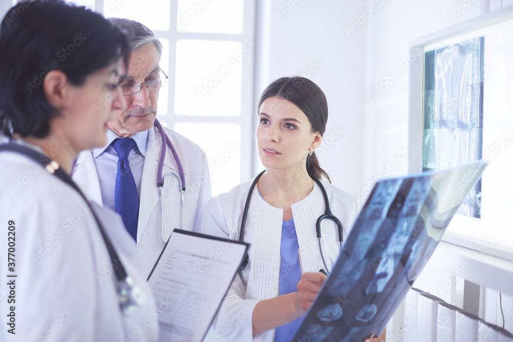 Group of doctors checking x-rays in a hospital Group of doctors checking x-rays in a hospital