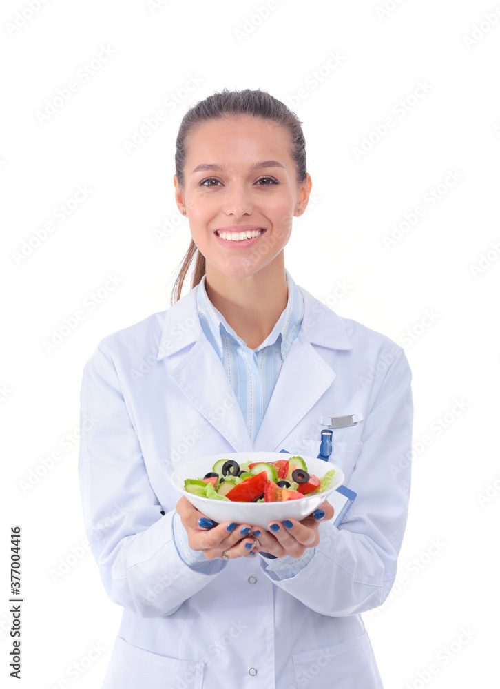 Portrait of a beautiful woman doctor holding a plate with fresh vegetables. Woman doctors. Portrait of a beautiful woman doctor holding a plate with fresh vegetables. Woman doctors.