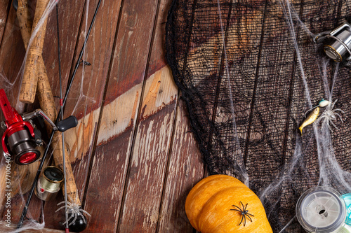 Fishing tacles on wooden background in Halloween designe with spaders and web photo