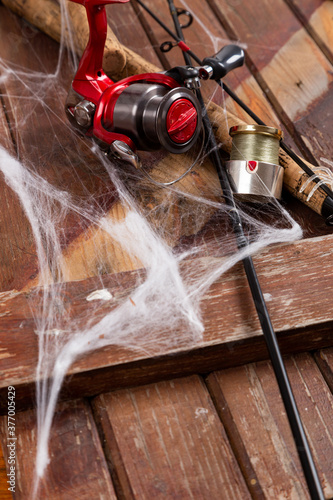 Fishing tacles on wooden background in Halloween designe with spaders and web