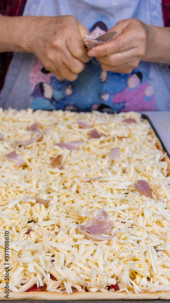 elderly woman white mother cutting sausages and sausages to make pizza elderly woman white mother cutting sausages and sausages to make pizza