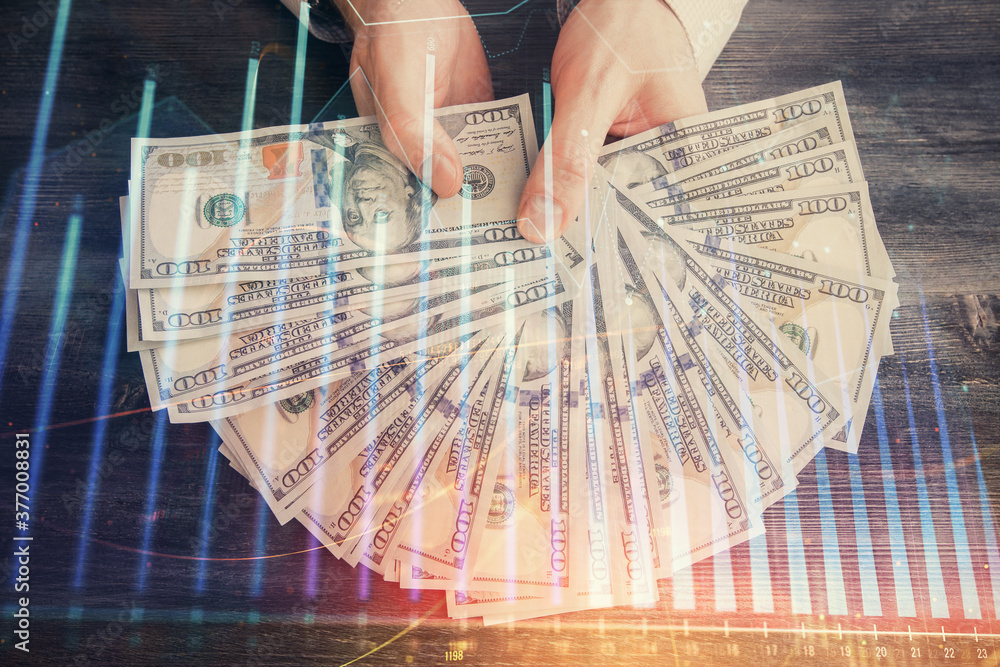 Multi exposure of financial graph drawing hologram and USA dollars bills and man hands. Analysis concept. Multi exposure of financial graph drawing hologram and USA dollars bills and man hands. Analysis concept.