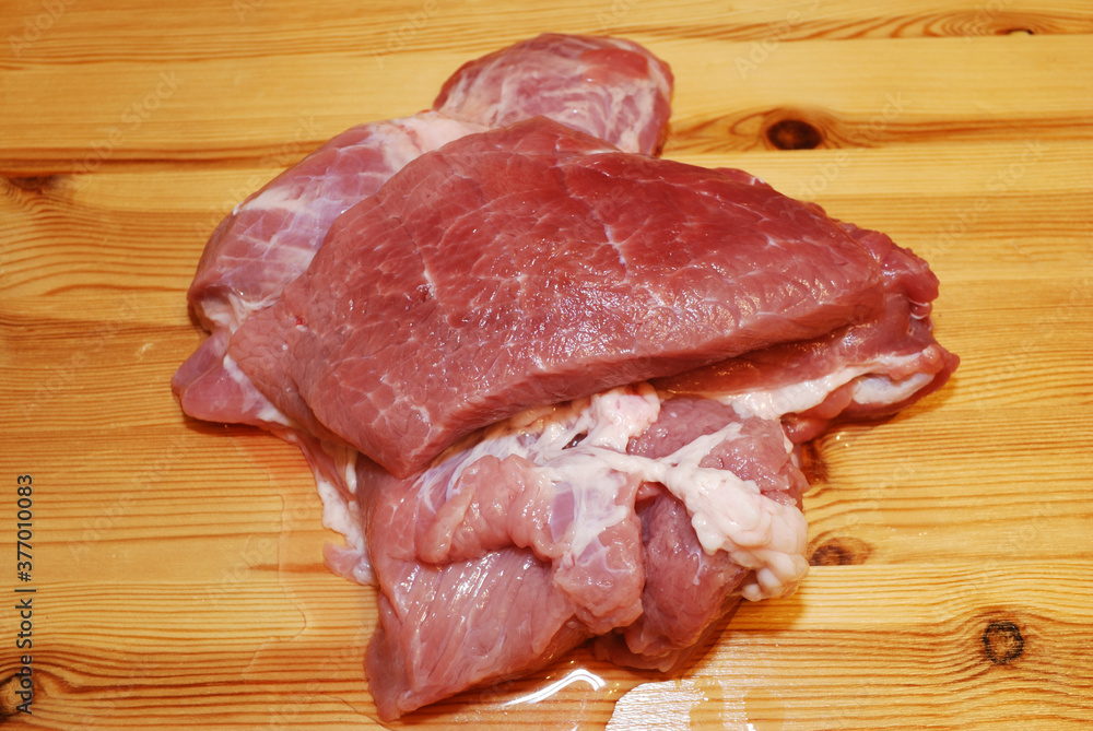 Piece of fresh pork meat on a wooden surface. Piece of fresh pork meat on a wooden surface.