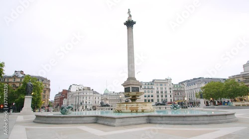 Lockdown in London, Slow motion Gilmbal walk of Empty Trafalgar Square during coronavirus pandemic 2020, with Nelson's Column & red London buses in empty streets with flying birds.