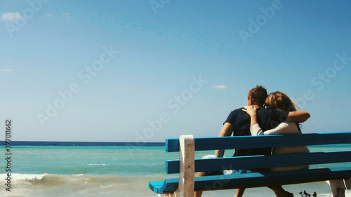 couple sitting on the beach © Evgenii Ryzhenkov