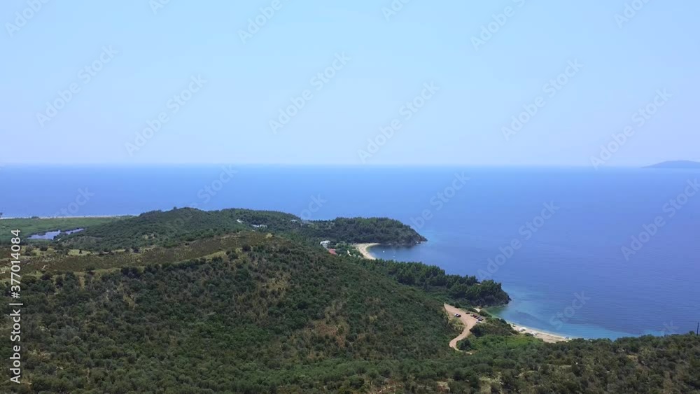 Hilly coast covered by pine trees and open blue sea in summer season. Aerial view Hilly coast covered by pine trees and open blue sea in summer season. Aerial view