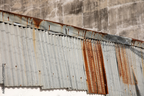 Obraz na plátně front view and close up shot of wavy roofing tiles which were made from metallic zinc shows the beautiful detail of its grunge surface texture with rusty and shadow of electricity cable line
