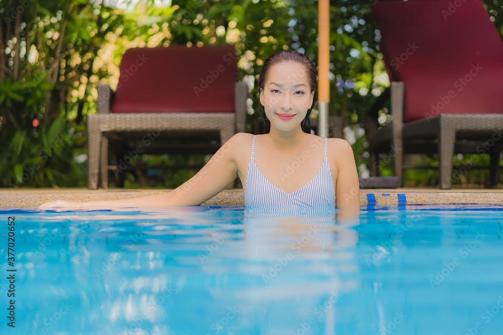 Portrait beautiful young asian woman enjoy relax smile leisure around outdoor swimming pool