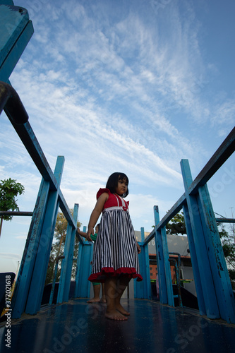 a little girl playing on a wooden swing in the city park of Bojonegoro, Indonesia photo