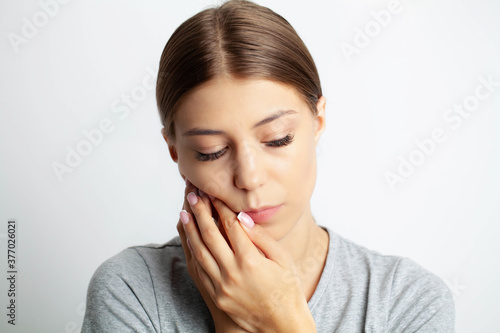 Close up of a beautiful young woman experiencing a painful toothache
