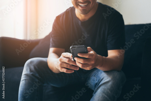 using cell phone.hand holding texting message on screen mobile chatting,search internet information sitting on sofa.technology device contact communication connecting people concept