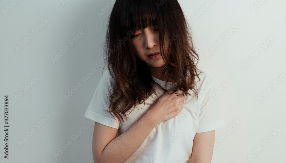 Asian woman get heartache while she sit at the white wall. Asian woman get heartache while she sit at the white wall.
