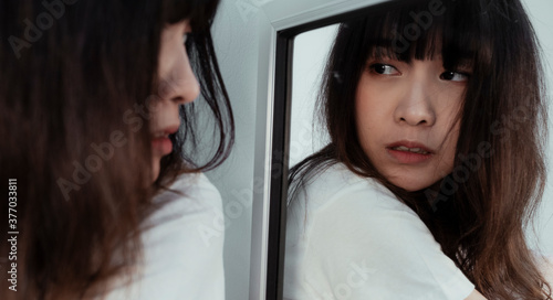 Fotografia Reflection of Thai girl looking for something in the emptiness frighten her